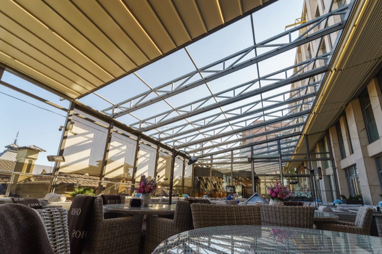 Terrasoverkapping met open lamellendak boven een loungeterras