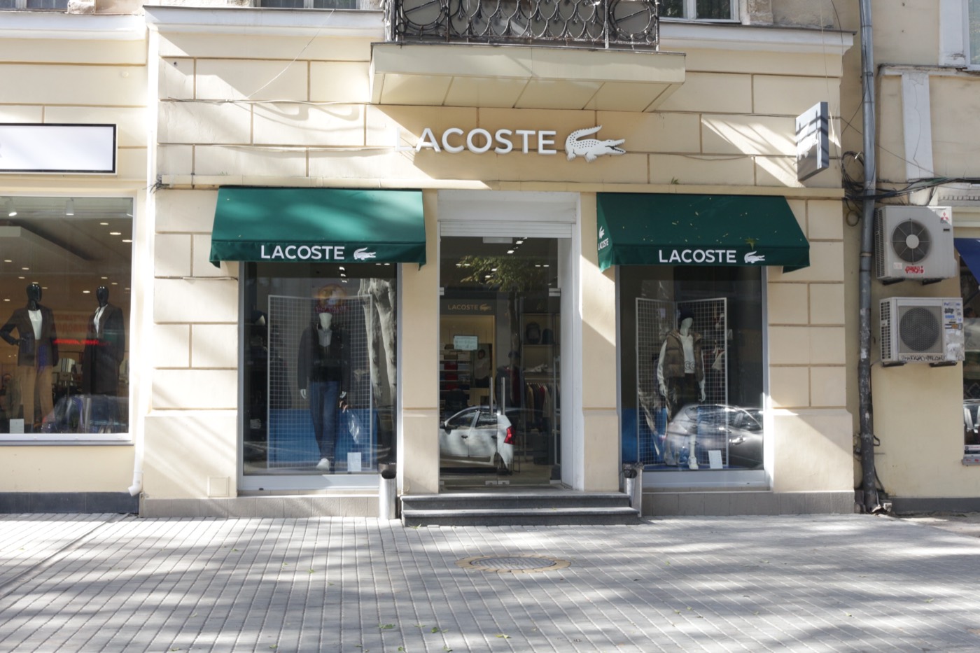Groene uitvalschermen op de gevel van een Lacoste-winkel
